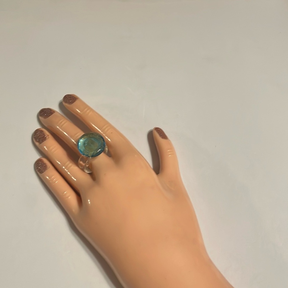 Clear acrylic ring w/a circle that is light blue w/gold glitter sprinkles inside